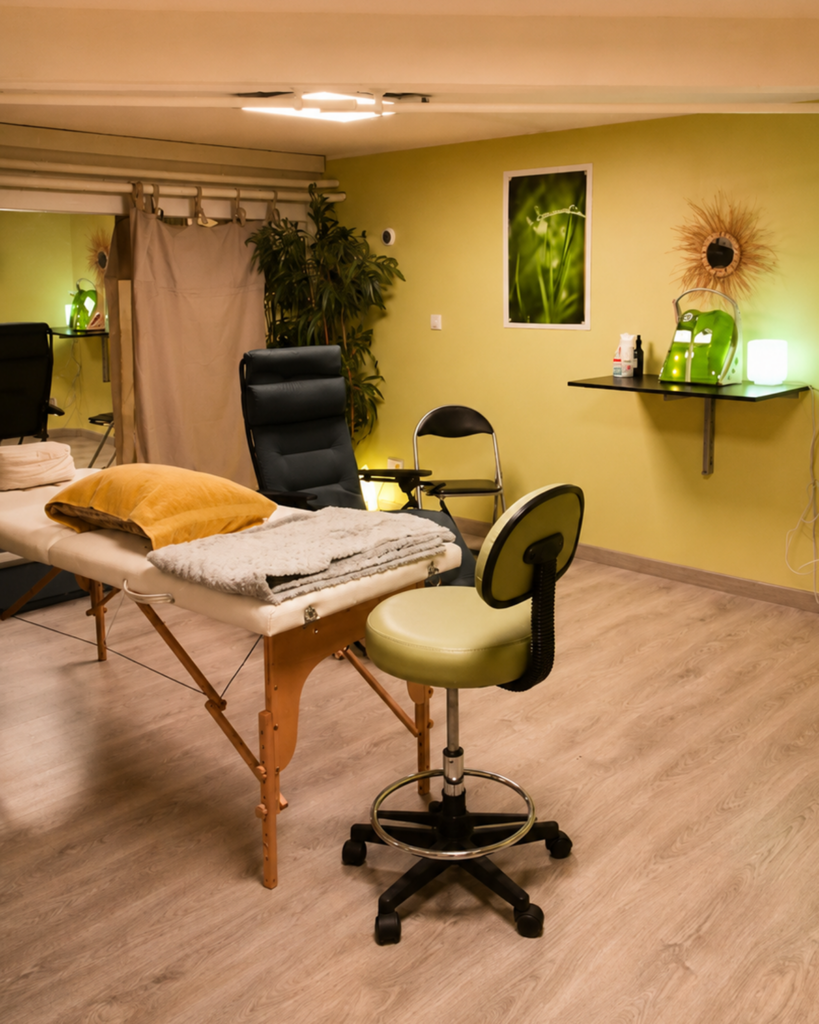 Salle de soin chaleureuse avec table de massage, fauteuil et ambiance douce dans le cabinet LITHA à Paris